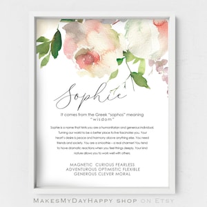 May include: A watercolor print with a floral design in shades of pink and green. The name "Sophie" is written in cursive script at the top of the print. The text below the name explains the meaning of the name and lists personality traits associated with it. The text reads: "It comes from the Greek "sophos" meaning "wisdom". Sophie is a name that hints you are a humanitarian and generous individual. Turning our world to be a better place to live fascinates you. Your heart's desire is peace and harmony above anything else. You need friends and society. You are a smoothie - a real charmer! You tend to have dramatic reactions when you feel things deeply. Your kind nature allows you to work well with others. MAGNETIC CURIOUS FEARLESS ADVENTUROUS OPTIMISTIC FLEXIBLE GENEROUS CLEVER MORAL"