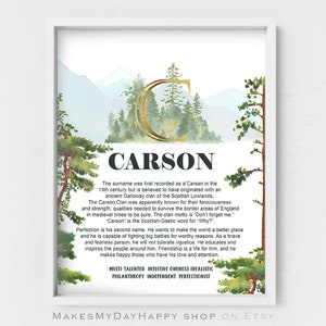 May include: A framed watercolor print featuring the name "Carson" in bold letters. The artwork includes a gold-colored initial "C" and a scenic background of trees and mountains. Text below details the name's origin and meaning.