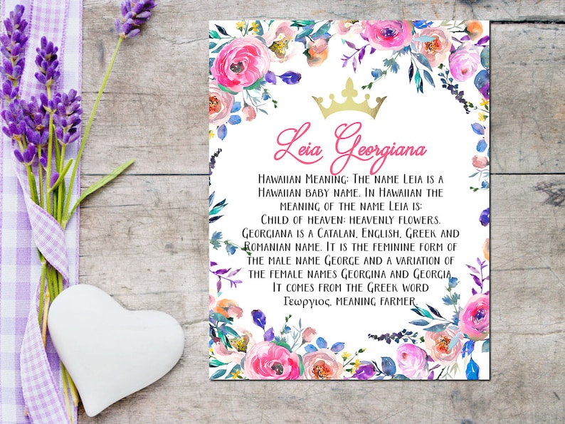 以下が含まれることがあります： ピンクとゴールドの王冠と「Lia Georgiana」というテキストが書かれた花柄のデザイン。下のテキストは、ハワイ語、カタロニア語、英語、ギリシャ語、ルーマニア語での名前の意味を説明しています。