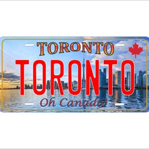 May include: A blue and gold license plate with a red Canadian flag in the top right corner. The plate says "TORONTO" in large red letters and "Oh Canada!" in smaller white letters. The background image is a cityscape of Toronto with the CN Tower in the center.