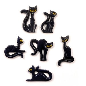Könnte beinhalten: Sechs schwarze Keramik-Katzenfiguren mit gelben Augen. Die Katzen sind in verschiedenen Posen, darunter sitzend, stehend und liegend.