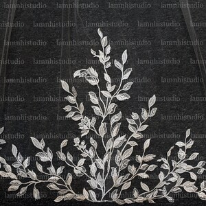 May include: A wedding veil with a detailed floral and leaf lace design. The white lace features intricate leaf shapes and a central floral element. The veil is sheer, with the lace forming a decorative border.