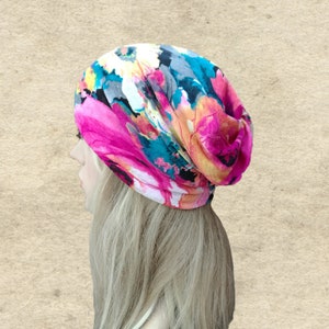 May include: A pink, blue, and white floral print beanie hat. The hat is made of a soft, stretchy fabric and is perfect for keeping your head warm in the winter.