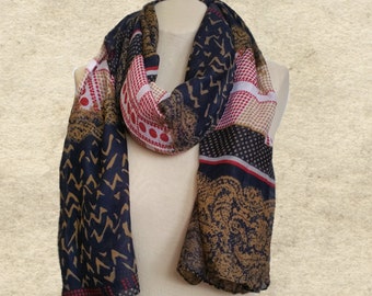 May include: A navy blue, red, white, and brown patterned scarf with a geometric design. The scarf is made of a soft, lightweight fabric and is perfect for adding a touch of style to any outfit.