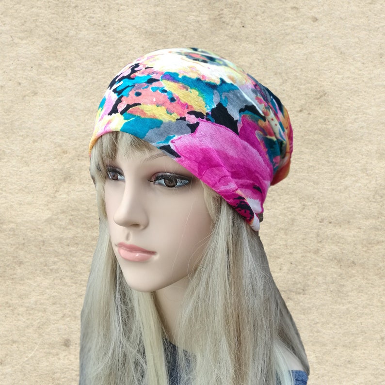 May include: A colorful floral print beanie hat with pink, blue, yellow, and white accents. The hat is made of a soft, stretchy fabric and is perfect for keeping your head warm in the winter.