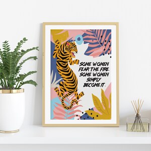 May include: A framed print with a colorful illustration of a tiger in a jungle setting. The text reads "Some women fear the fire. Some women simply become it."