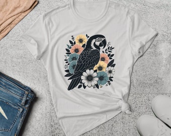 May include: White t-shirt with a black and blue parrot surrounded by colorful flowers.