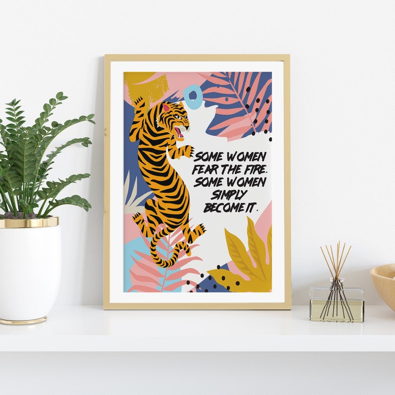 May include: A framed print with a colorful illustration of a tiger in a jungle setting. The text reads "Some women fear the fire. Some women simply become it."