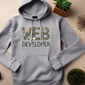 May include: Gray hooded sweatshirt with the text "WEB DEVELOPER" in green letters with floral designs.