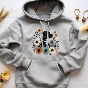 May include: A gray hoodie with a black silhouette of a dog surrounded by colorful flowers. The hoodie has a drawstring hood and a kangaroo pocket.