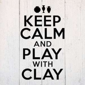 May include: A black and white sign with the text "KEEP CALM AND PLAY WITH CLAY" in bold letters. Three black pottery silhouettes are above the text. The background is a white, weathered wood.