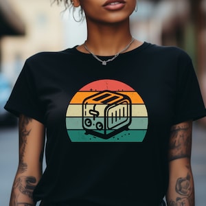 May include: A black t-shirt with a vintage-style graphic of a toaster in front of a sunset. The graphic has a distressed look with a faded orange, yellow, and blue color scheme.