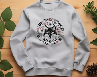 May include: A light gray sweatshirt with a black and white fox head design surrounded by a floral wreath. The flowers are pink and white.