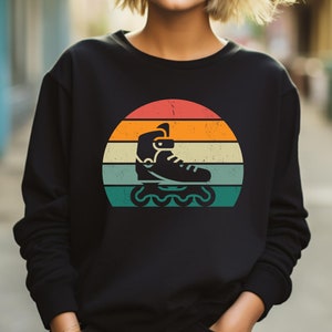 May include: Black sweatshirt with a vintage-style graphic of a roller skate on a sunset background.