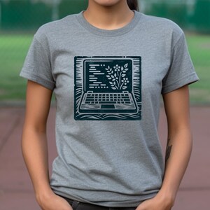 May include: A gray t-shirt with a dark blue screen printed design of a laptop with a plant growing out of the screen.
