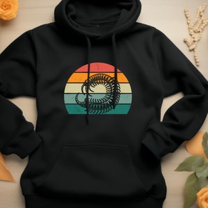 May include: Black hoodie with a vintage-style graphic of a curled-up centipede in front of a sunset. The graphic has a faded, distressed look.