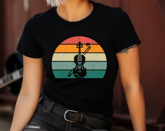 May include: A black t-shirt featuring a vintage-style graphic of a violin and bow in front of a sunset. The sunset is a multi-coloured gradient of orange, yellow, and blue.