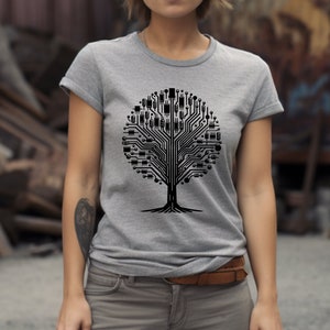 以下が含まれることがあります： 黒い回路基板の木のデザインがプリントされた灰色のTシャツ