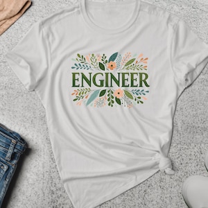 Puede incluir: Camiseta blanca con un diseño floral verde y la palabra "ENGINEER" en letras verdes.