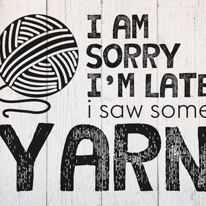 Puede incluir: Cartel en blanco y negro con un ovillo de lana y el texto "I AM SORRY I'M LATE I SAW SOME YARN" sobre un fondo de madera blanca. Un artículo divertido para un espacio de manualidades.
