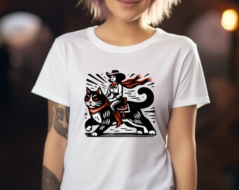 May include: White t-shirt with a black and white illustration of a person wearing a cowboy hat riding a black cat.
