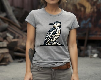 May include: A gray t-shirt with a black and white illustration of a woodpecker perched on a branch.