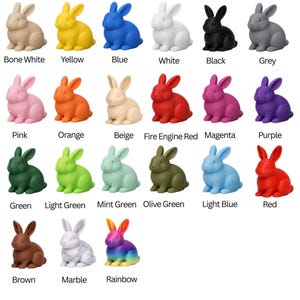 A grid of 18 solid-color rabbit figurines, each with a color label below it, including Bone White, Yellow, Blue, White, Black, Grey, Pink, Orange, Beige, Fire Engine Red, Magenta, Purple, Green, Light Green, Mint Green, Olive Green, Light Blue, Red