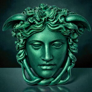 A vibrant green Medusa head sculpture with serpent hair and a braided chin piece, set against a dark background.