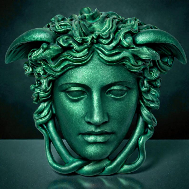 A vibrant green Medusa head sculpture with serpent hair and a braided chin piece, set against a dark background.