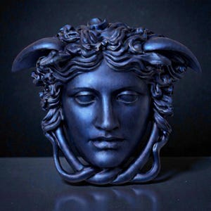 A dark blue Medusa head sculpture with snakes for hair and under the chin, against a dark background.