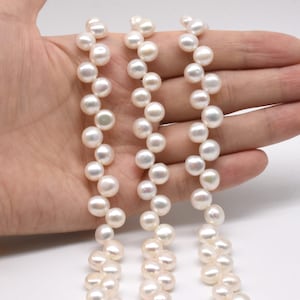 Puede incluir: Tres hebras de perlas de agua dulce blancas, cada hebra mide aproximadamente 45 cm de largo. Las perlas son redondas y tienen un acabado liso y brillante.