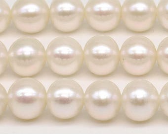 May include: A strand of white round pearls, arranged in three rows.