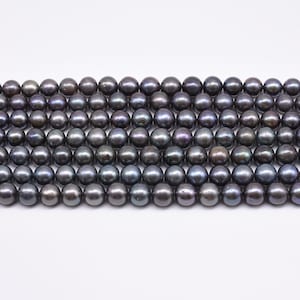 May include: A strand of black freshwater pearls. The pearls are round and have a slight iridescent sheen.