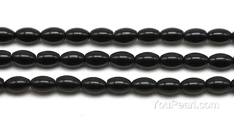 May include: A strand of black oval-shaped beads. The beads are smooth and glossy.