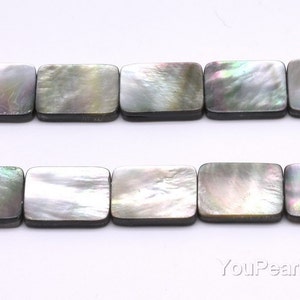 Puede incluir: Una hebra de cuentas rectangulares de concha negra e iridiscente. Las cuentas tienen un acabado liso y pulido y están enhebradas en un hilo transparente.