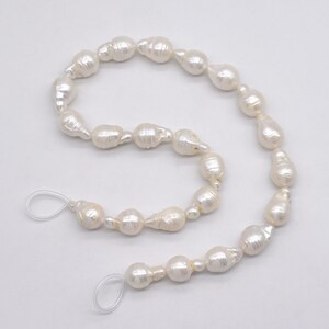 May include: A strand of white baroque pearls with a knotted string and clear plastic clasps.