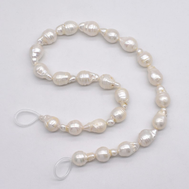May include: A strand of white baroque pearls with a knotted string and clear plastic clasps.