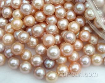 May include: A close-up of a pile of round, iridescent pearls in shades of pink and white. The pearls are smooth and glossy, and they are arranged in a random pattern.