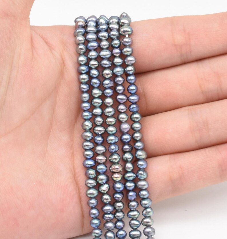 May include: A strand of gray freshwater pearls, approximately 5mm in size, strung on a thin thread. The pearls have a slightly iridescent sheen.