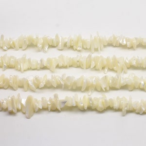 Puede incluir: Una hebra de cuentas de chip de madreperla blanca. Las cuentas son irregulares en forma y tama&ntilde;o, y tienen un brillo natural iridiscente.