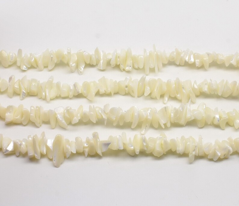 Puede incluir: Una hebra de cuentas de chip de madreperla blanca. Las cuentas son irregulares en forma y tama&ntilde;o, y tienen un brillo natural iridiscente.