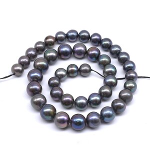 May include: A strand of black pearls with iridescent hues. The pearls are round and smooth, and they are strung on a black thread.
