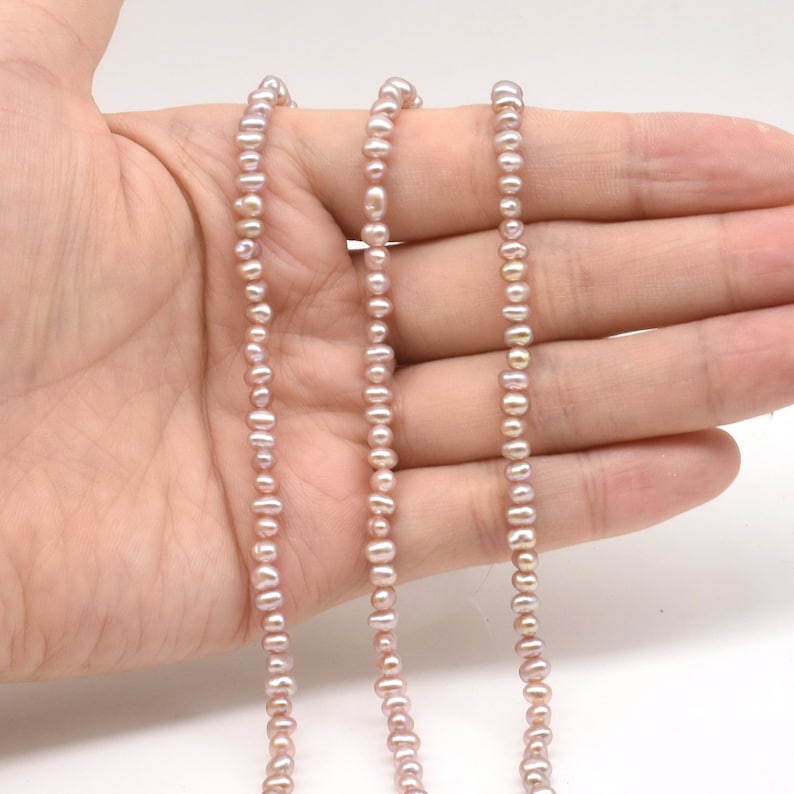 May include: A strand of pale pink freshwater pearls, strung on a thin thread. The pearls are small and uniform in size, creating a delicate and elegant look.