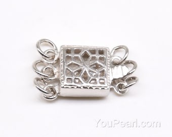 May include: Silver-toned metal clasp with a decorative, openwork design. The clasp has four loops for attaching a necklace or bracelet.