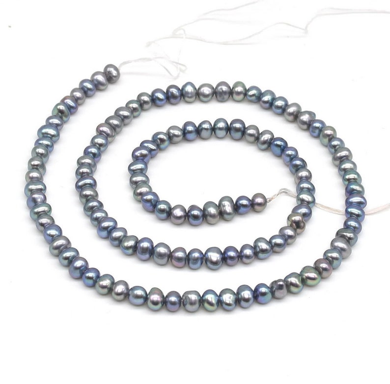 May include: A strand of gray freshwater pearls with iridescent blue and green hues. The pearls are strung on a white thread and are available in various lengths.