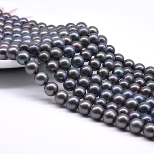 May include: A strand of black freshwater pearls. The pearls are round and have a slight iridescent sheen.