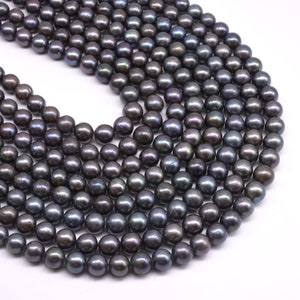 May include: A strand of dark gray freshwater pearls. The pearls are round and smooth, with a slight iridescent sheen.