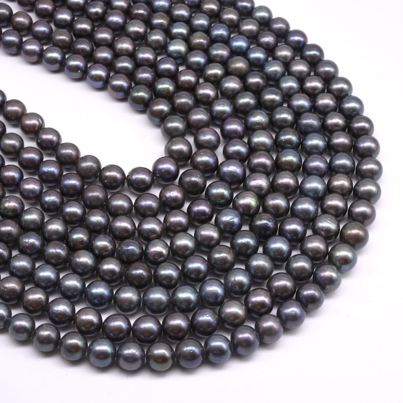 May include: A strand of dark gray freshwater pearls. The pearls are round and smooth, with a slight iridescent sheen.