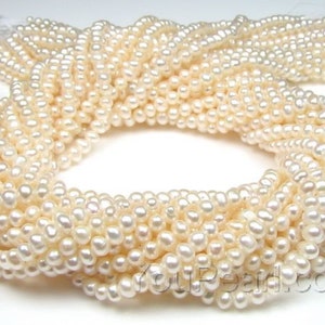 Puede incluir: Una hebra de perlas de agua dulce blancas, de aproximadamente 4-5 mm de tamaño. Las perlas son redondas y lisas, con un alto brillo. Son perfectas para hacer joyas.