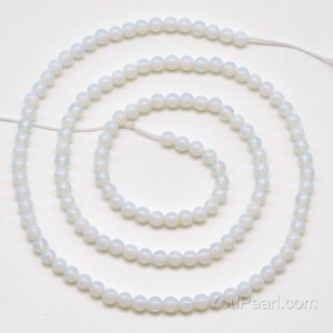 May include: A strand of white opal beads, approximately 6mm in diameter, strung on a white thread. The beads are round and have a smooth, polished finish.